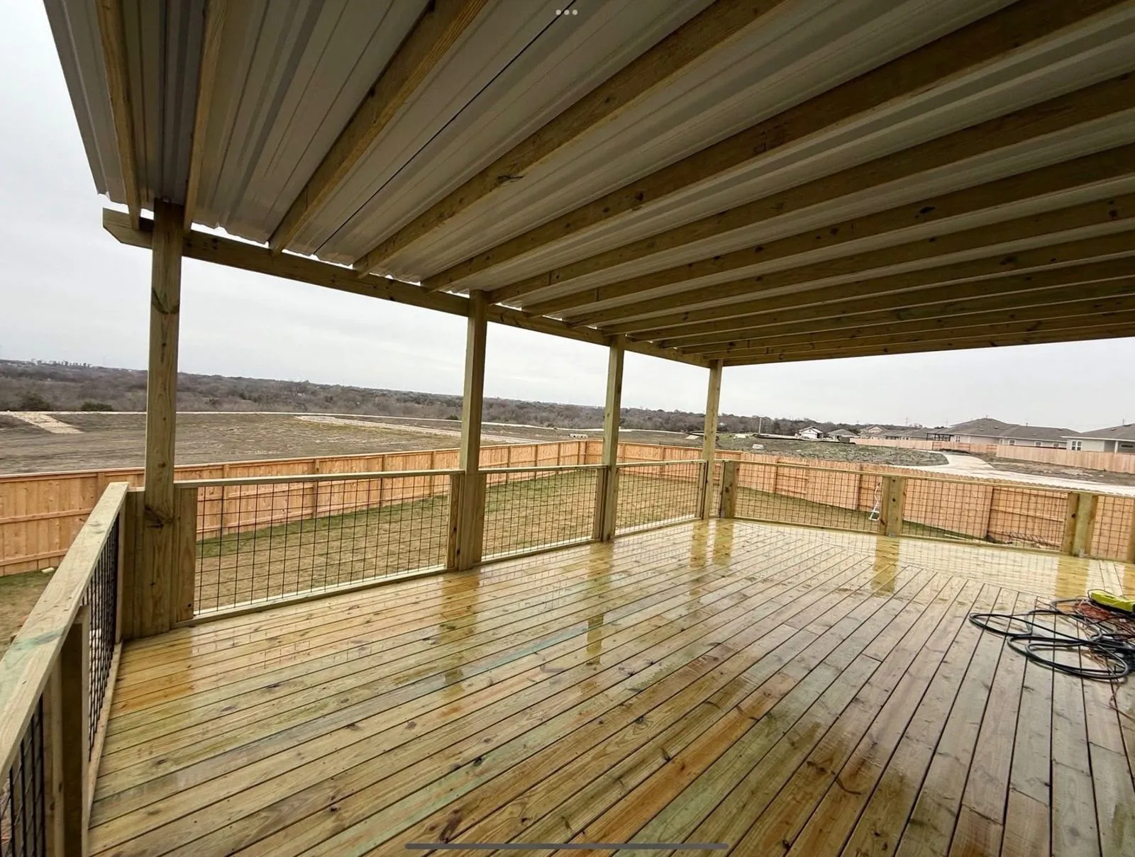 Covered deck with a metal roof and a Hill Country view