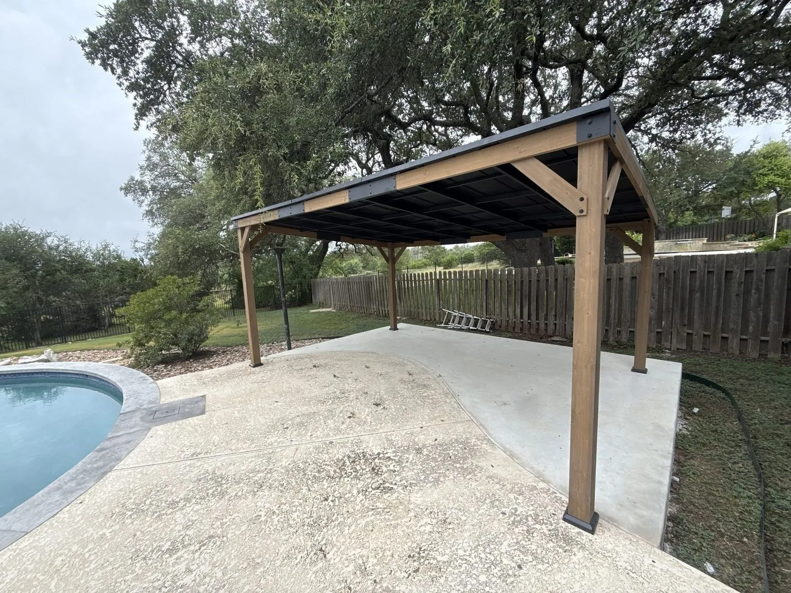 Cedar pavilion with a metal roof beside a pool